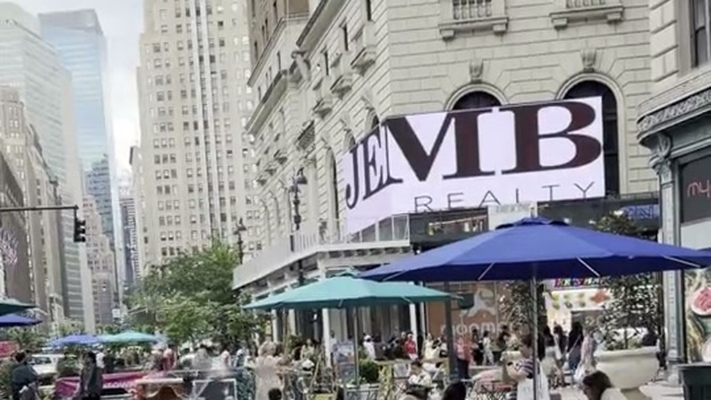 Herald Square pedestrian plaza with café tables and Midtown Manhattan buildings